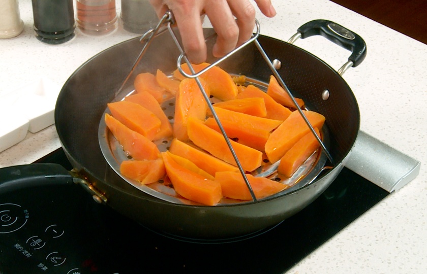 Use tongs to take out the sweet potatoes